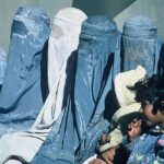 医療クリニックの外で待つアフガニスタンのチャドリに身を包んだ女性の画像